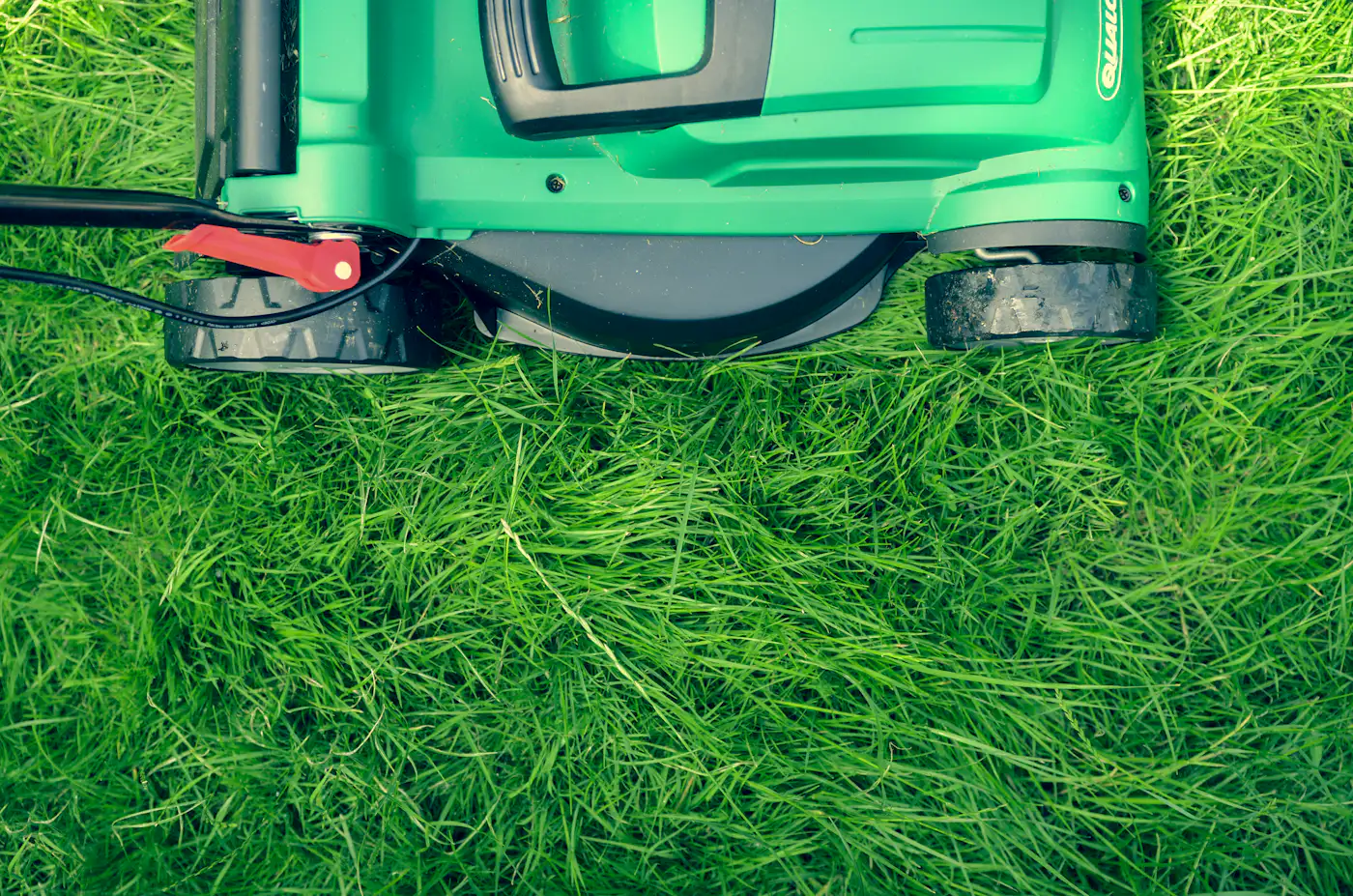 A lawnmower on freshly cut green grass