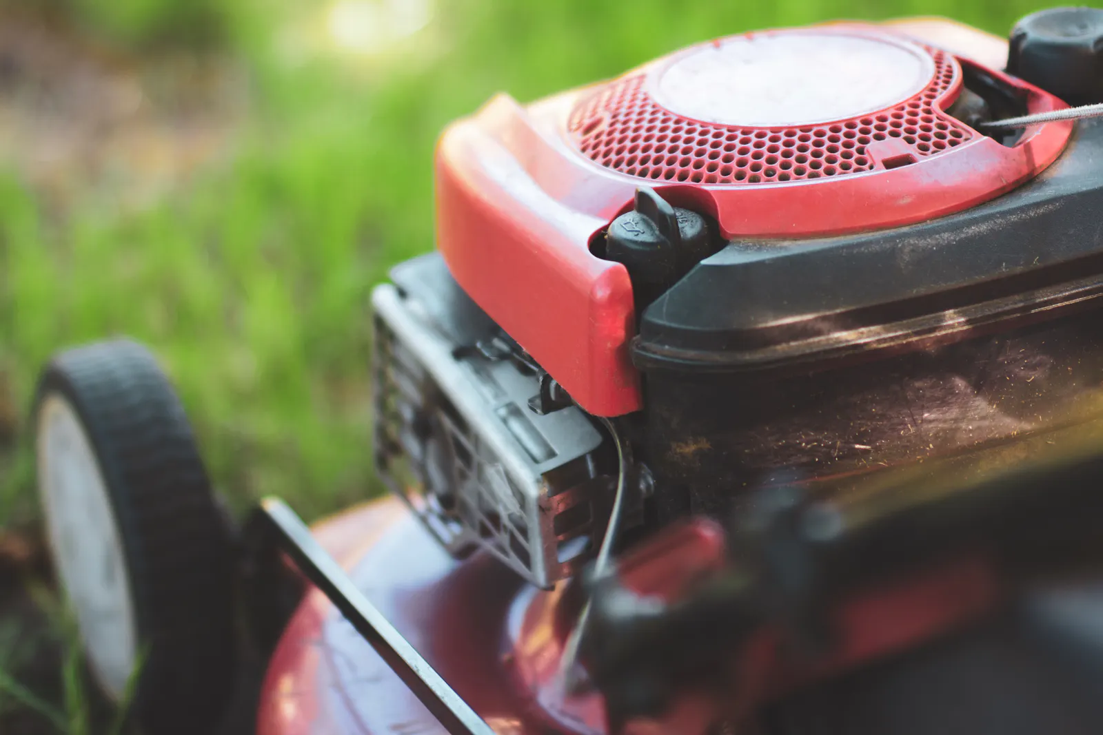 A red lawn mower on a lush green field
