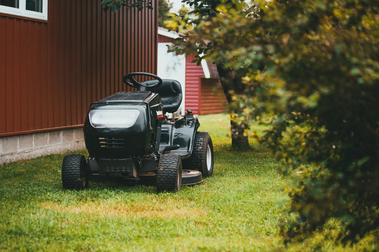 A zero-turn mower parked on a wide green lawn